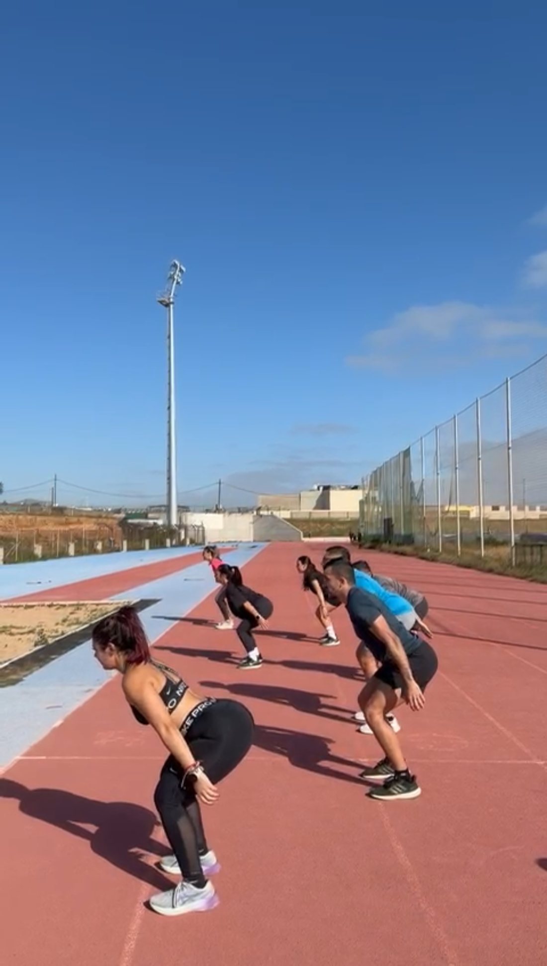 Grupo entrenando en pista de atletismo